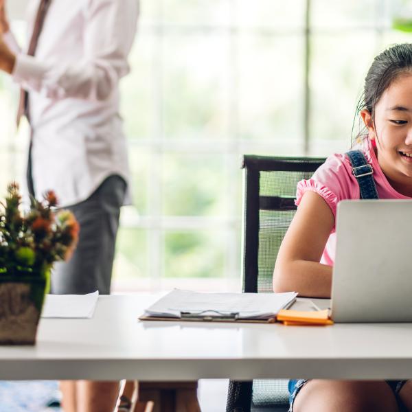 elementary age child working at home on her laptop