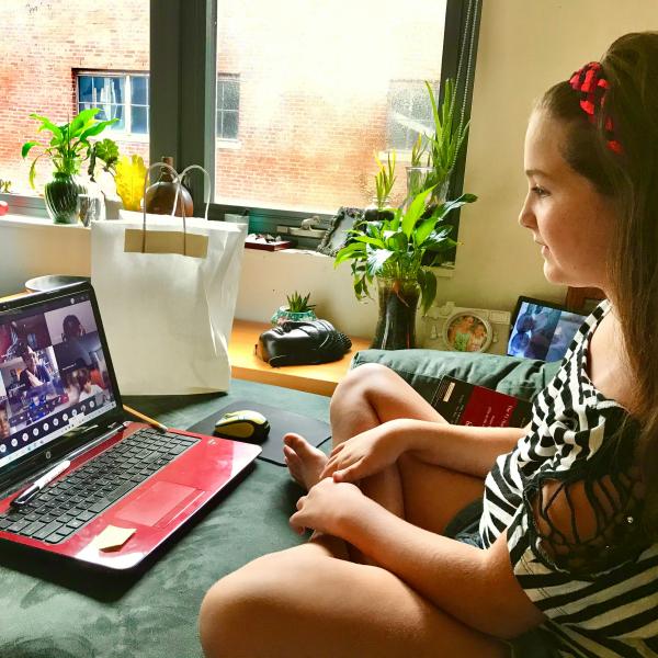 elementary girl working with online classmates via her laptop