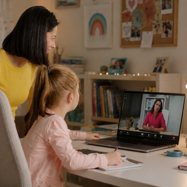 Parent and student at home talking to online teacher