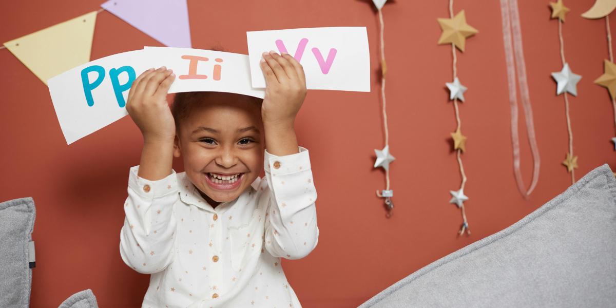 Smiling child learning letters
